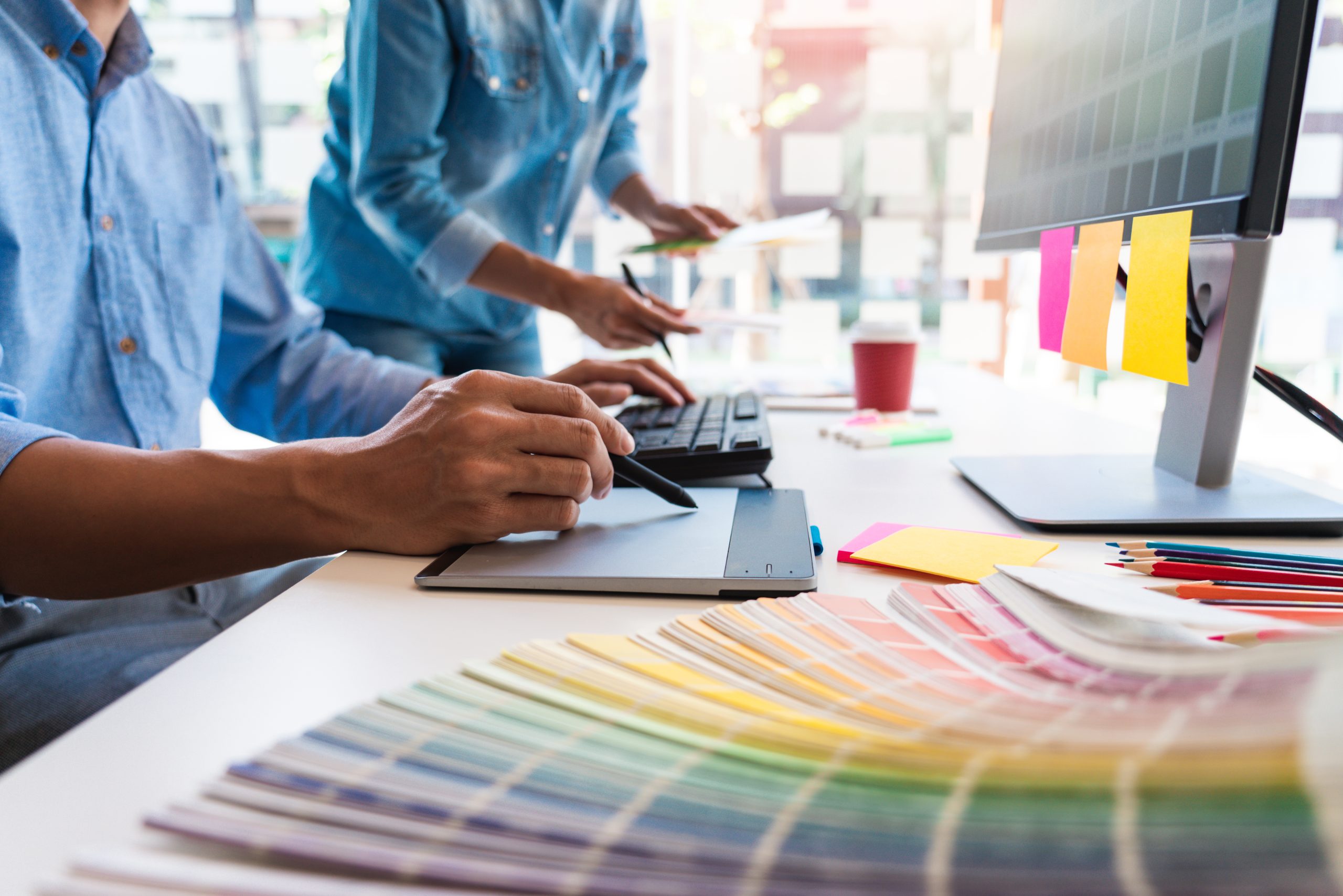 designer graphic creative creativity working together coloring using graphics tablet stylus desk with colleague scaled 1